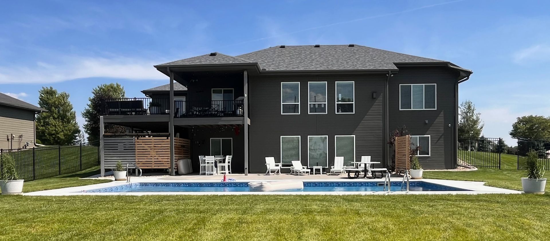 Wide view of a finished inground pool and patio built by Olympic Pool & Spa in the Omaha metro