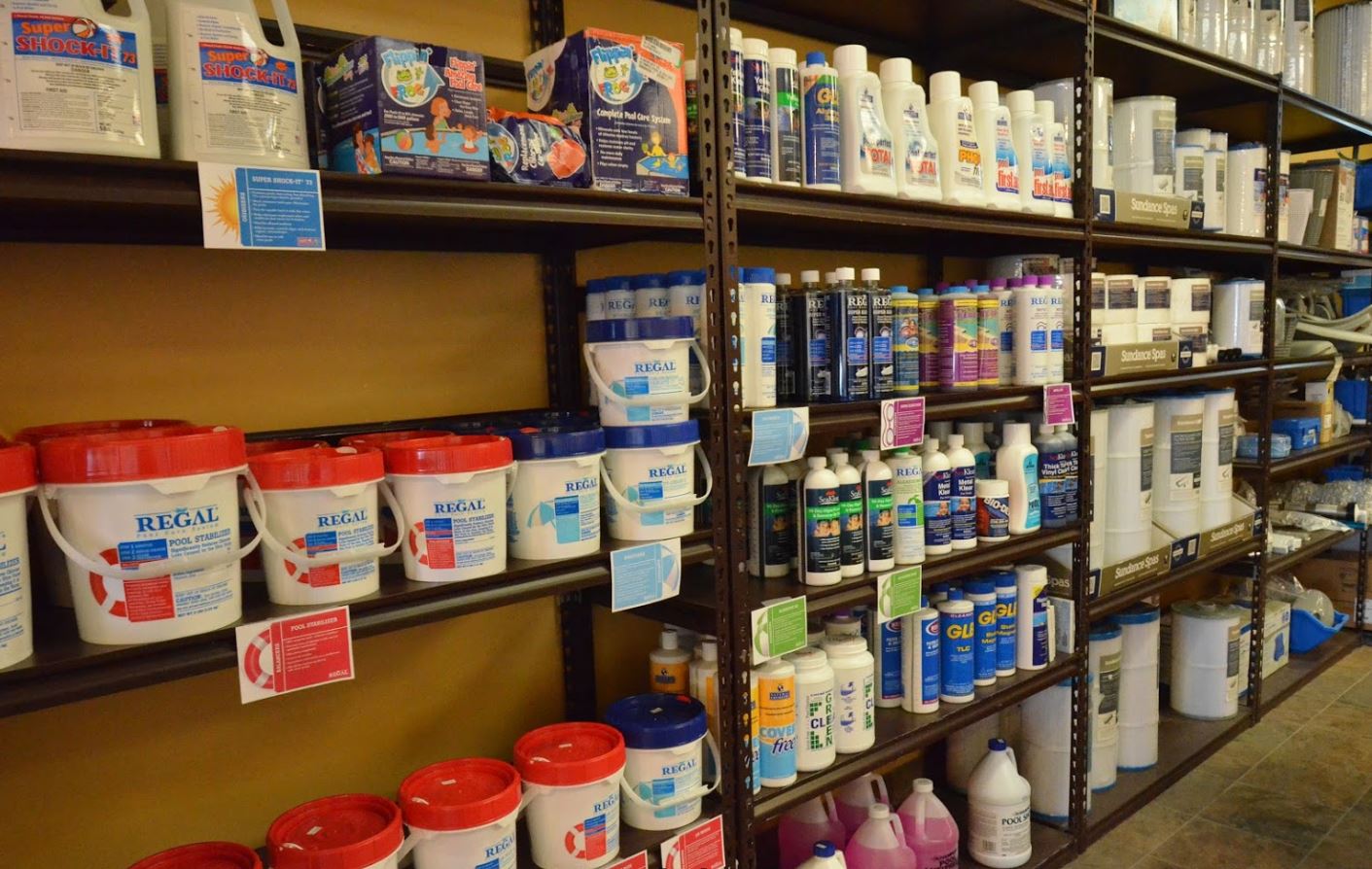 Pool and spa chemicals, filters, and water-care supplies on the shelves at Olympic Pool & Spa