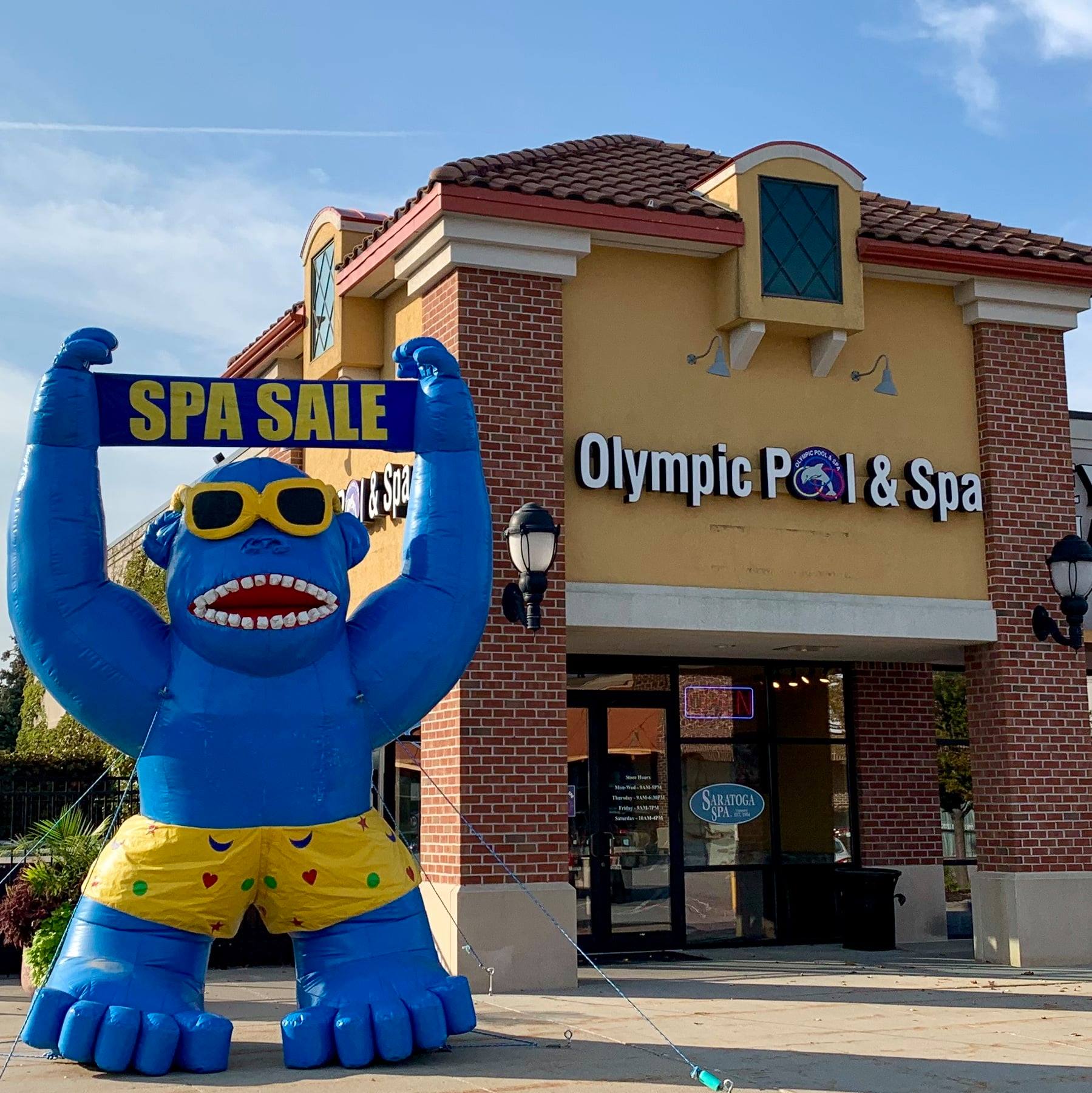 The Olympic Pool & Spa storefront at Wright Plaza in Omaha, inflatable gorilla and Spa Sale banner out front, where Splash Superpools are sized and sold