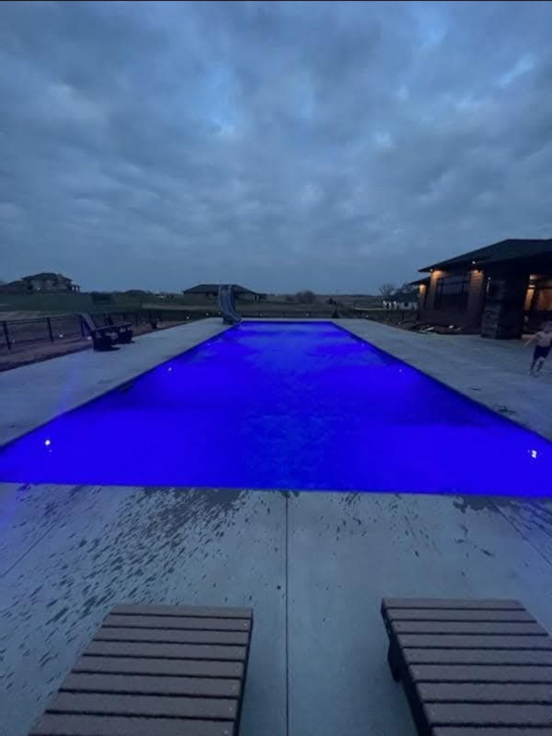 Backyard pool lit at dusk